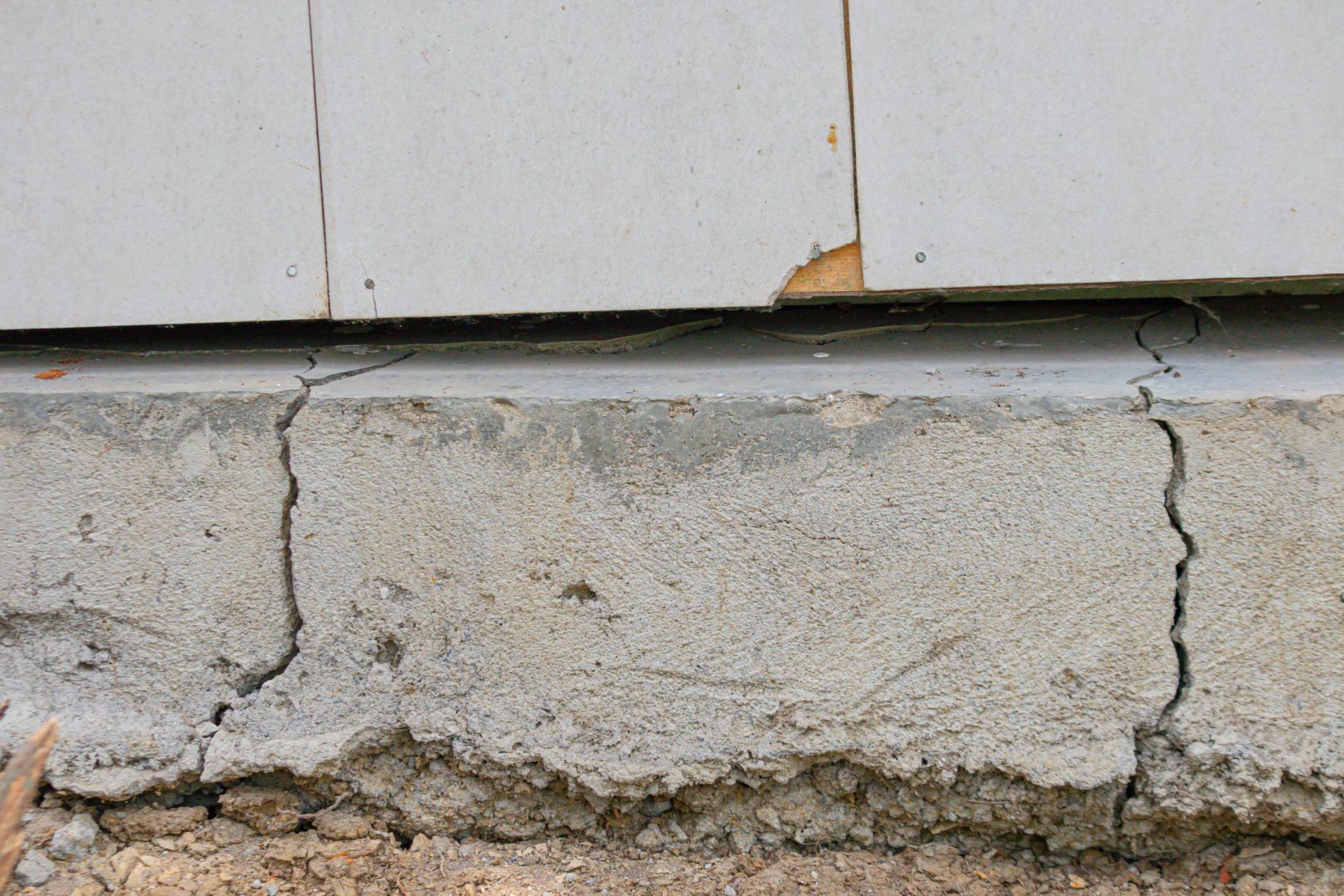 Concrete foundation with visible cracks, ideal for storm damage repair assessment.